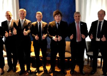 Grupo de ocho personas de traje posando de pie con los pulgares en alto frente a un fondo azul, entre ellas el presidente argentino Javier Milei, en el anuncio del proyecto Agua Rica.