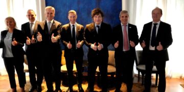 Grupo de ocho personas de traje posando de pie con los pulgares en alto frente a un fondo azul, entre ellas el presidente argentino Javier Milei, en el anuncio del proyecto Agua Rica.