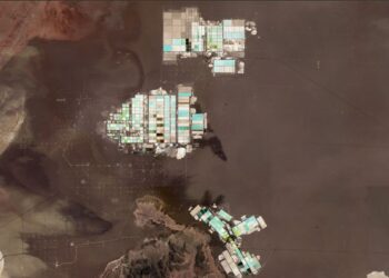 Vista satelital de las pozas de evaporación de litio en el Salar de Atacama, con estanques de tonos turquesa, verdes y blancos sobre la superficie oscura del salar.